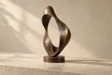 Sculpture de bronze fictive Élan, boucle organique ouverte sur un socle circulaire.