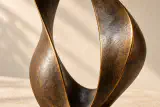 Gros plan simulé de la patine sombre et du bord doré de la sculpture de bronze Élan.