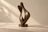 Sculpture de bronze fictive Élan vue en perspective, avec son ruban torsadé et son socle circulaire.